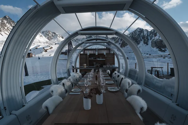 Interior del restaurante bulthaup Grandvalira, con la mesa preparada y las cumbres al fondo