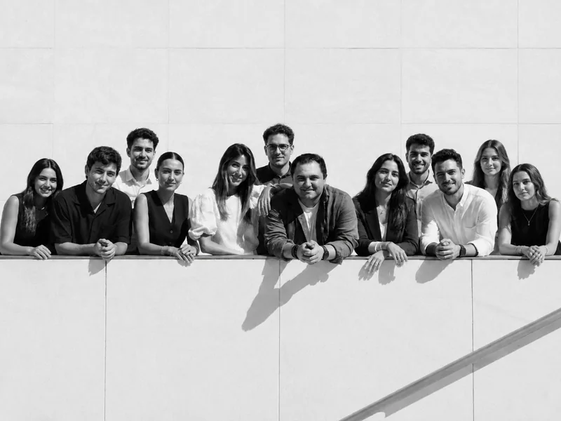 The ALLÓ The Agency team, photographed in black and white against the wall of the office roof terrace